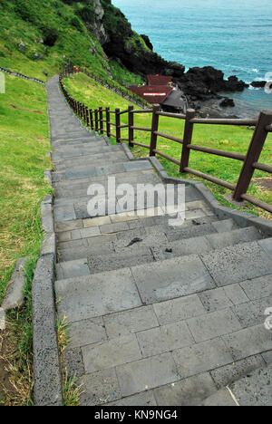 Long flight of stairs with wooden railings leading down into the sea. Suitable for concepts such as business and sales, economic downturn, financial c Stock Photo
