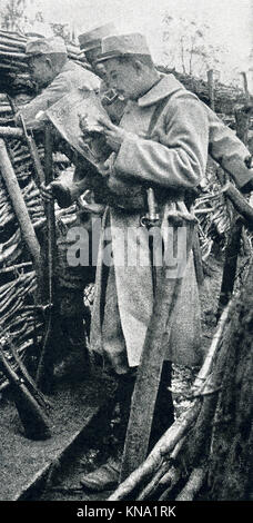The caption for this photo that dates to between 1914 and 1917 (time of the First World War) reads: Scene in the first-line trenches, where papers, particularly illustrated ones, are much in demand. Stock Photo
