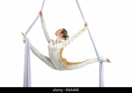 Pretty woman - aerialist performing aerial tricks on aerial silks. Studio shooting on a white background. Stock Photo