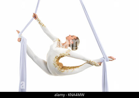 Pretty woman - aerialist performing aerial tricks on aerial silks. Studio shooting on a white background. Stock Photo