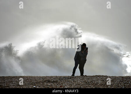 Couple kissing on a beach with a stormy sea Stock Photo