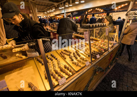 Market stall traders serve food and drink to customers at Manchester Christmas Markets Around The City, Manchester, England, UK Stock Photo