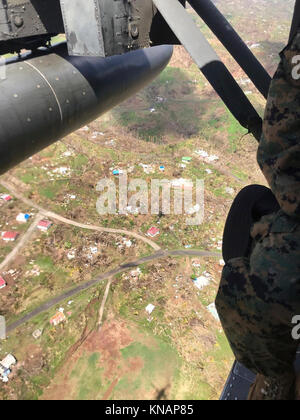 U.S. service members fly over the Caribbean island of Dominica, Oct. 9, 2017. The island was devastated by Hurricane Maria, a Category 5 storm that made landfall Sept. 19, 2017, spurring support from the Joint Base Lewis-McChord community, as well as military installations across the globe. Stock Photo