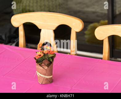 Artificial flower pot used as a centerpiece for an outdoor party. Stock Photo