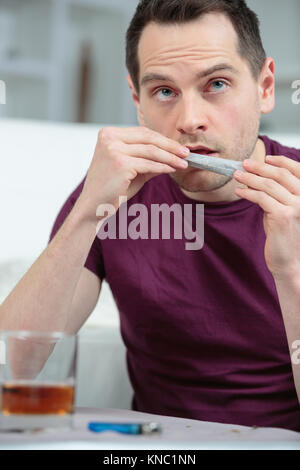male rolling a cigarette with rolling tobacco Stock Photo