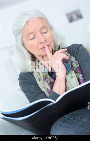 Elderly woman browsing old photographs at a village history open day ...