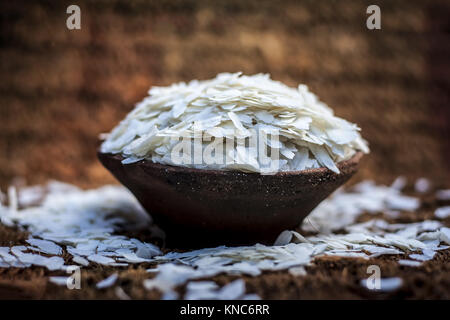 Oryza sativa,Puffed rice in a clay bowl on a gunny background. Stock Photo