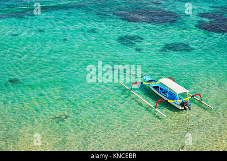 Indonesian outrigger canoe, also known as jukung or cadik moored in Mendira Bay. Candidasa, Manggis subdistrict, Karangasem regency, Bali, Indonesia. Stock Photo