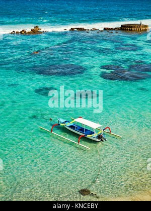 Indonesian outrigger canoe, also known as jukung or cadik moored in Mendira Bay. Candidasa, Manggis subdistrict, Karangasem regency, Bali, Indonesia. Stock Photo