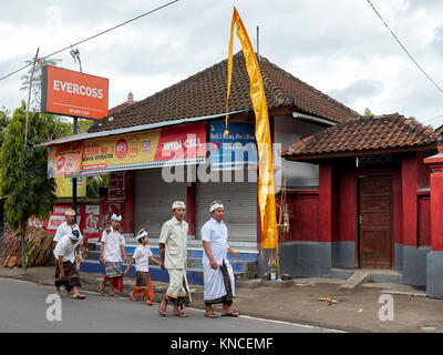 People wearing traditional Balinese clothing go to a local temple near Bugbug village. Karangasem Regency, Bali, Indonesia. Stock Photo