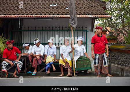 Local men wait for starting of a religious ceremony at local temple near Bugbug village. Karangasem Regency, Bali, Indonesia. Stock Photo