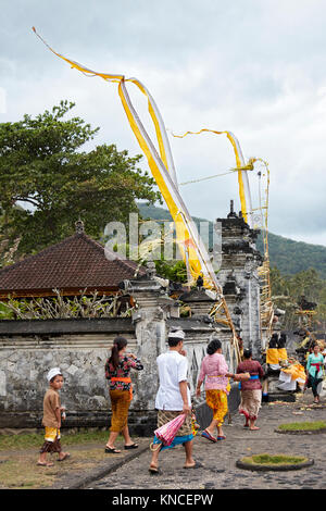 People wearing traditional Balinese clothing in front of a local temple. Sengkidu village near Candidasa, Karangasem Regency, Bali, Indonesia. Stock Photo