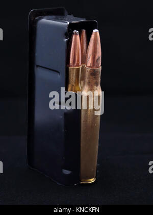 A fully loaded rifle magazine stood up on a black background Stock Photo