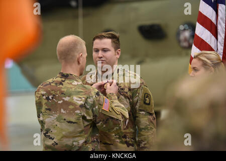 ANSBACH, Germany – Col. Kenneth Cole, 12th Combat Aviation Brigade (CAB) Commander presents an award to the outgoing Headquarters and Headquarters Company, 12th CAB Commander Cpt. William McGinnis. Katterbach Army Airfield, Dec. 6, 2017 (U.S. Army Stock Photo