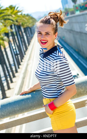 Nosing around, having fun. happy trendy woman in yellow shorts and stripy shirt outdoors in the city Stock Photo