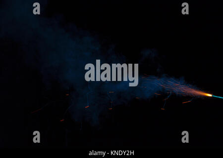 Burning fuse with sparks and blue smoke on black background Stock Photo