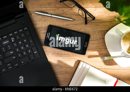 WROCLAW, POLAND - NOVEMBER 17th, 2017: Samsung A5 is laying on the desk with imgur logo on screen. Imgur is an online image sharing community and imag Stock Photo