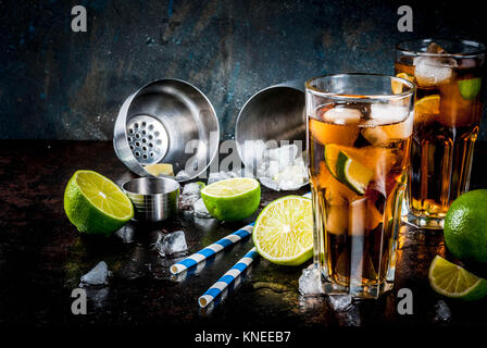 Cuba Libre, long island or iced tea cocktail with strong alcohol, cola, lime and ice, two glass, dark background copy space Stock Photo