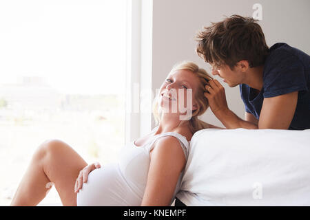 Romantic pregnant couple in bedroom Stock Photo