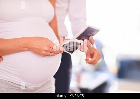 Cropped shot of pregnant couple looking at ultrasound pictures Stock Photo