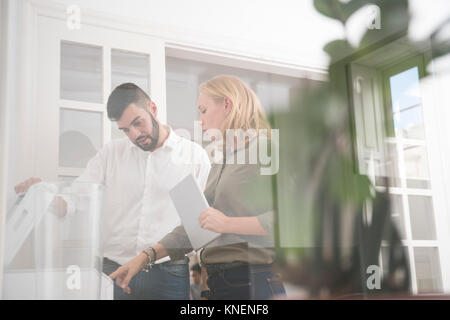Computer technician and businesswoman looking at office photocopier Stock Photo