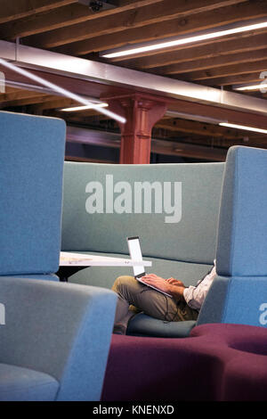 Side view of man in booth using laptop Stock Photo
