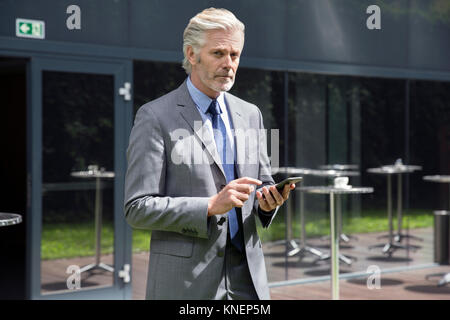 Businessman texting on smartphone Stock Photo