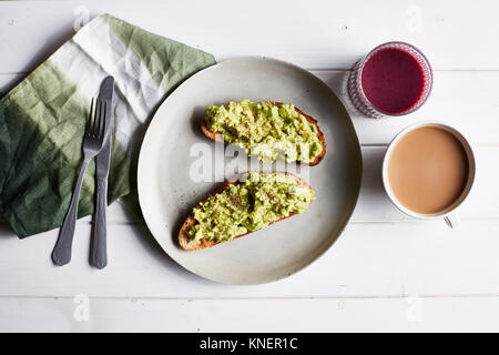 Avocado on toast on white plate, overhead view