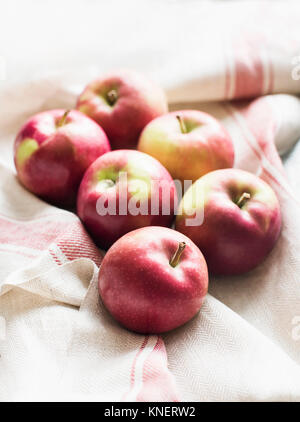Six red apples on linen kitchen cloth, close-up Stock Photo