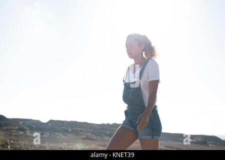 Young female hiker hiking in sunlit landscape, Las Palmas, Canary Islands, Spain Stock Photo