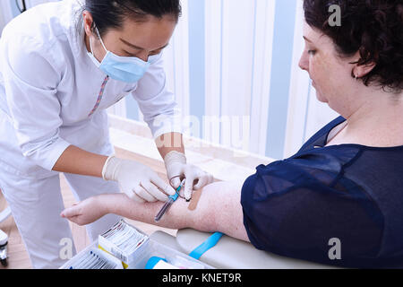 Medical professional performing blood test Stock Photo