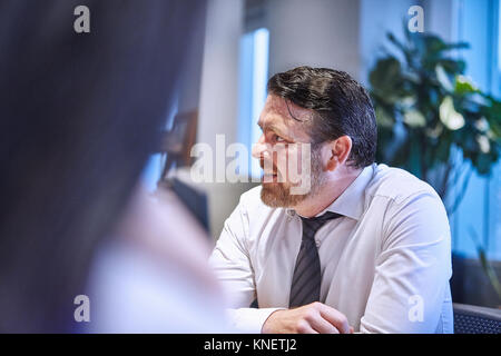 Businessman in office looking away smiling Stock Photo
