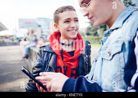 Young couple looking at smartphone in city