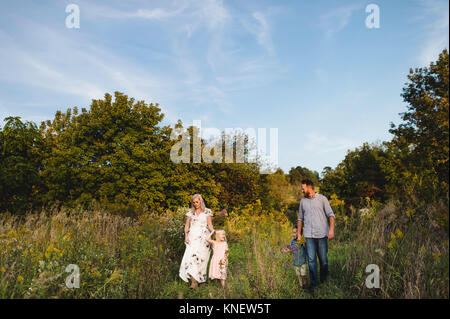 Family walking in tall grass together Stock Photo