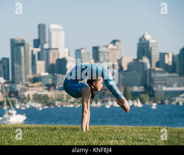 Teenage girl outdoors, balancing on hands in yoga position Stock Photo