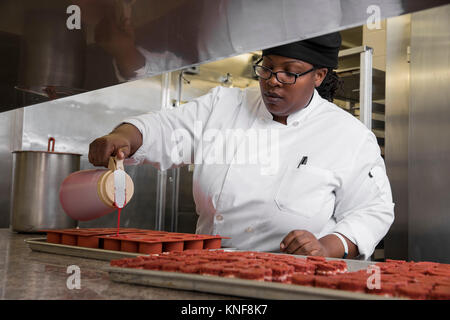 Chef in commercial kitchen preparing cakes Stock Photo