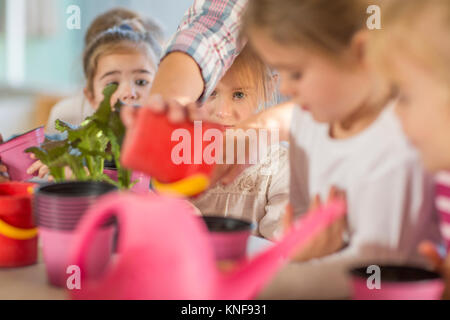 Woman helping young children with gardening activity Stock Photo
