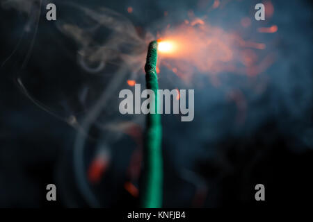 Burning fuse with sparks and grey smoke on black background Stock Photo