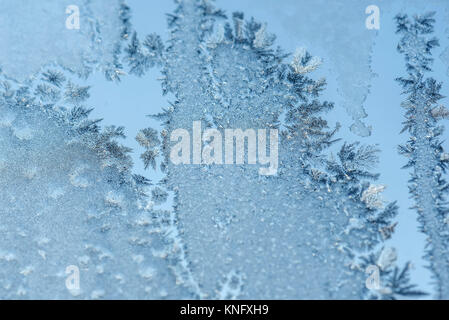 Beautiful abstract winter background with frosty icy and snowy pattern on the window at dawn Stock Photo