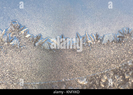Beautiful abstract winter background with frosty icy and snowy pattern on the window at dawn Stock Photo