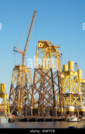 Terex crane with offshore wind turbine supports at Smulders Hadrian Yard on the Tyne, Wallsend, north east England, UK Stock Photo