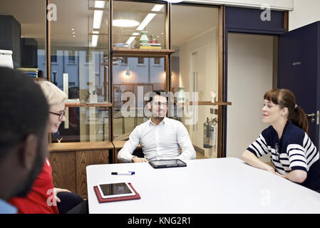 Group of young professionals in a business meeting in a contemporary office Stock Photo