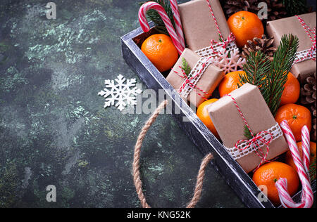 Christmas or New Year composition with tangerines, candy canes and gift boxes Stock Photo