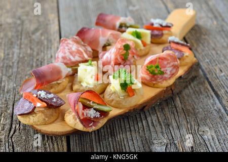 South Tyrolean appetizers: Local crunchy rye bread with smoked bacon, hearty wine cheese and Italian salami Stock Photo