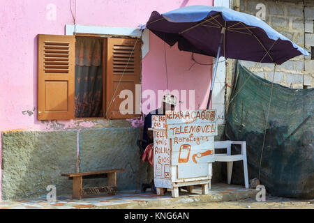 Man repairing watches and mobile phones from a small stall in a back street of Santa Maria, Sal Island, Cape Verde, Africa Stock Photo