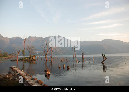 Early morning at Lake Atitlan in Guatemala which is surrounded by high cliffs and overlooked by three volcanoes Stock Photo