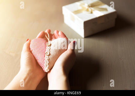Woman hand holding a gift box. A gift from a heart, charity, case and thoughtful presents Stock Photo