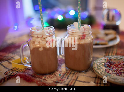 Two mugs with cocoa and marshmallows are on the Christmas table. Stock Photo