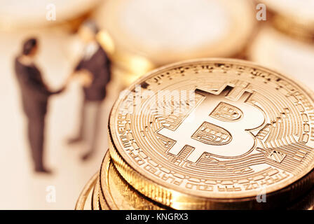 Bitcoin and businessmen in the background shaking hands. Stock Photo