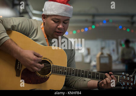 A U.S. soldier plays Christmas carols on a guitar during a holiday celebration at the Bagram Air Field December 25, 2016 in Bagram, Afghanistan. (photo by Katherine Spessa  via Planetpix) Stock Photo